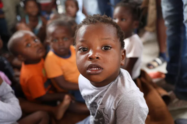 Un enfant d&eacute;plac&eacute; regarde la cam&eacute;ra.
