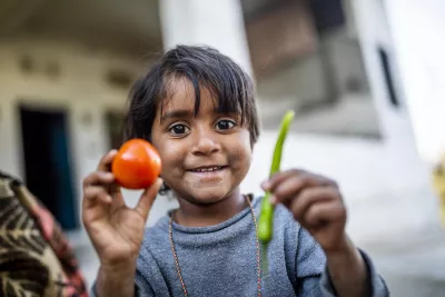 A child learns while playing with vegetables at her house in Kundaal, Rajasthan.