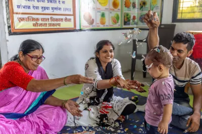 Anganwadi worker Minakshi Mankar teaches games to Nilesh Rathor and his wife, Pooja, to play with their one-year-and-one-month-old son, Vihan, at Anganwadi no. 76 in Samtanagar, Warud village, District of Amravati, Maharashtra, India, 21 October 2024.