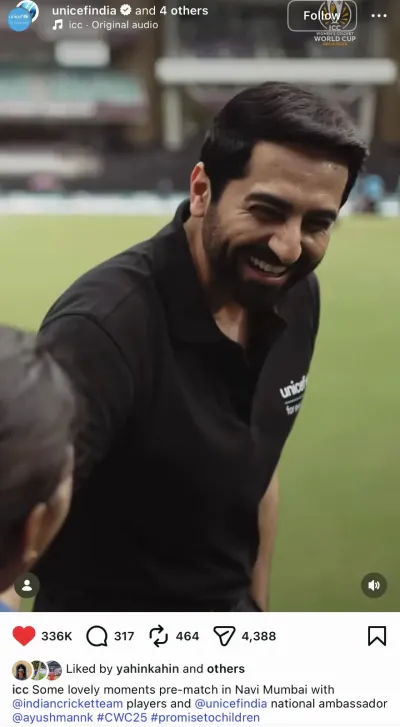 Ayushmann Khurrana in a black UNICEF polo shirt laughing joyfully while interacting with Indian women's cricket team players on the field at the ICC Women's Cricket World Cup 2025 in Navi Mumbai.