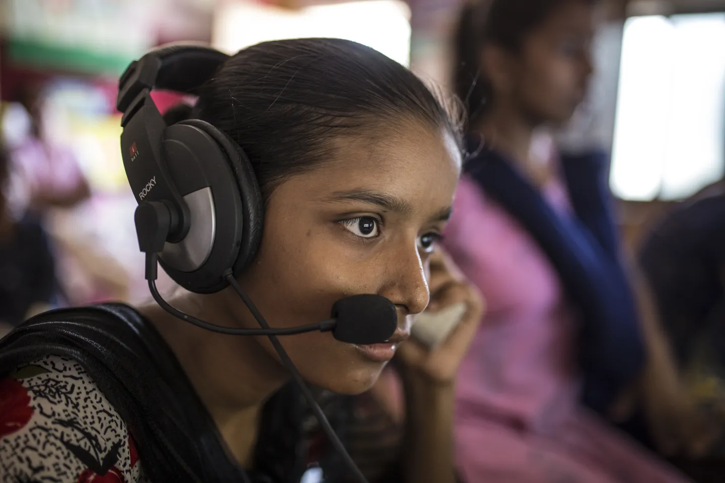 Sandhya Sahu listens audio from computer inside Child Resource Centre at slums of Shivaji Nagar in Mumbai, India.