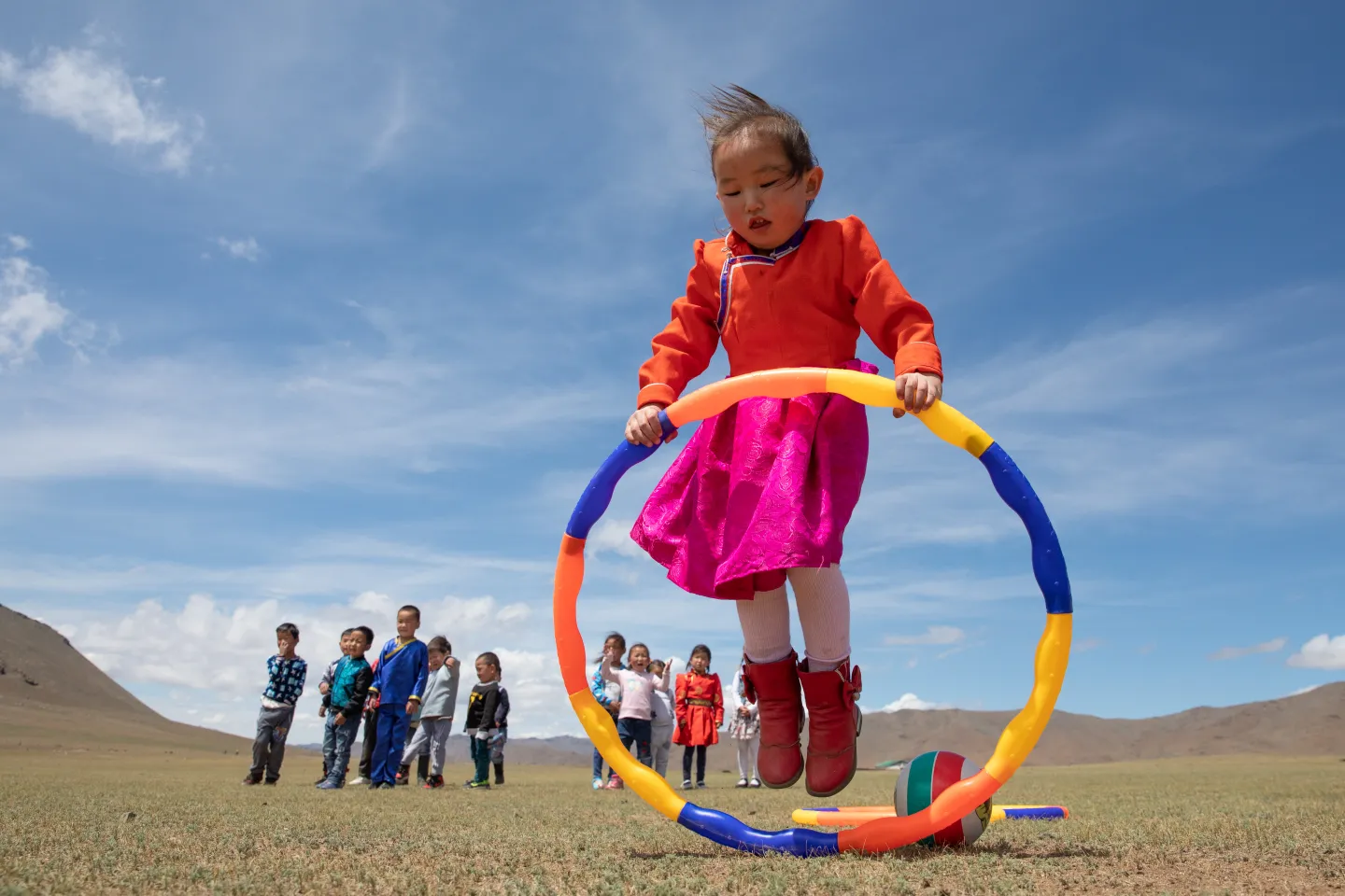 Khulan, 5, plays with a hoop outdoors during a recreation period at the newly opened mobile &lsquo;ger&rsquo; (traditional nomadic tent) kindergarten in the Janjin bagh area, in Erdenetsogt soum in Bayankhongor Province.