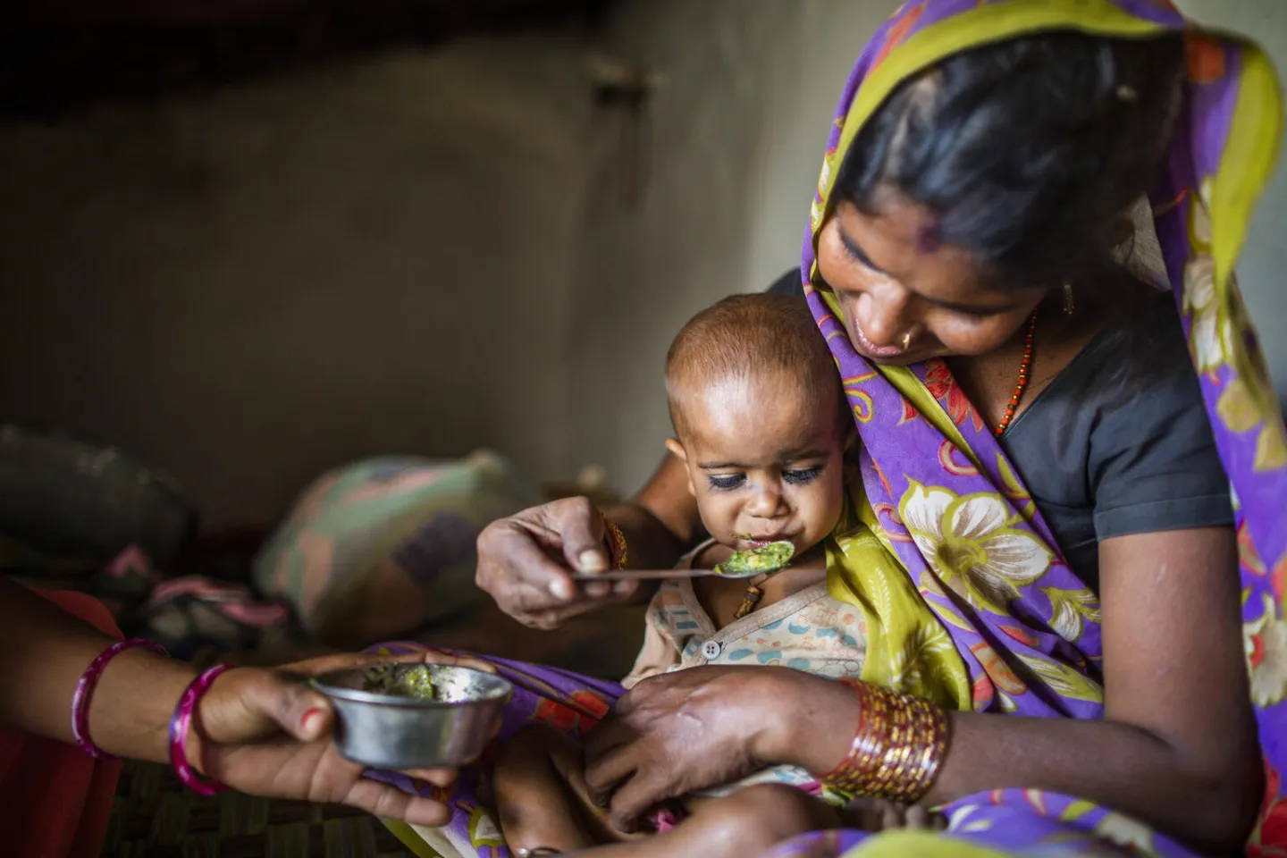 Bitti feeds nutritious food to her 2 years old child Basu.