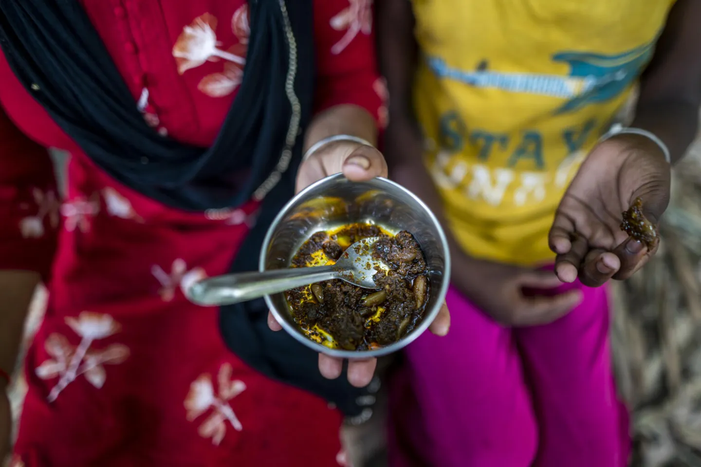 Two girls hold a bowl of pickle