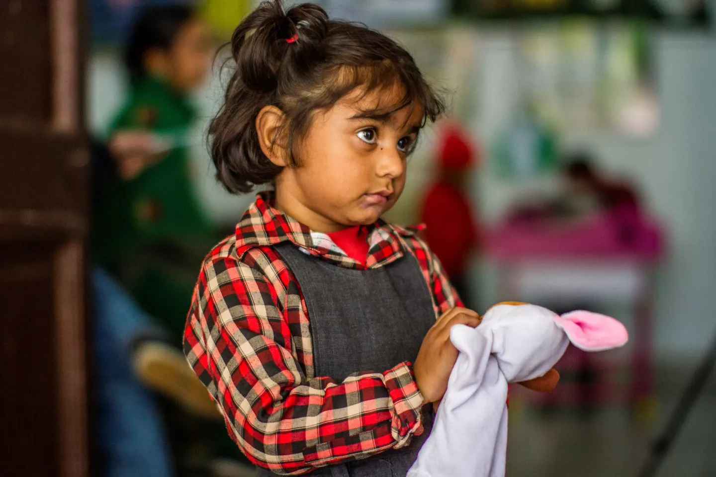 A girl plays holding a fluffy toy plays in a classroom of Ranbir Pahal Kindergarten, Jammu.
