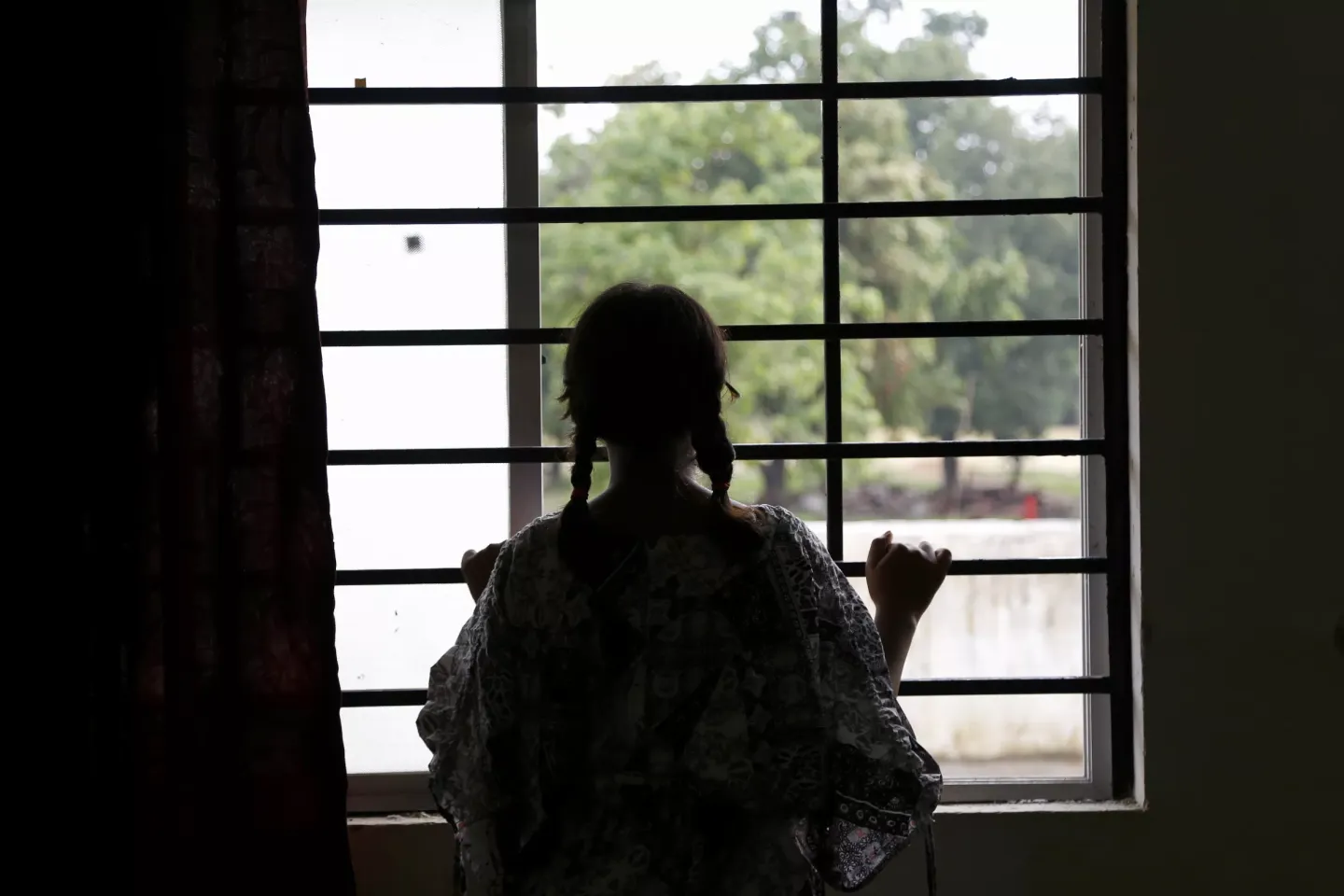A twelve-year-old girl gazes out the window following a psychosocial group session at the Eklavya Model Residential School for Girls (EMRS) in Dantewada, Chhattisgarh, India.