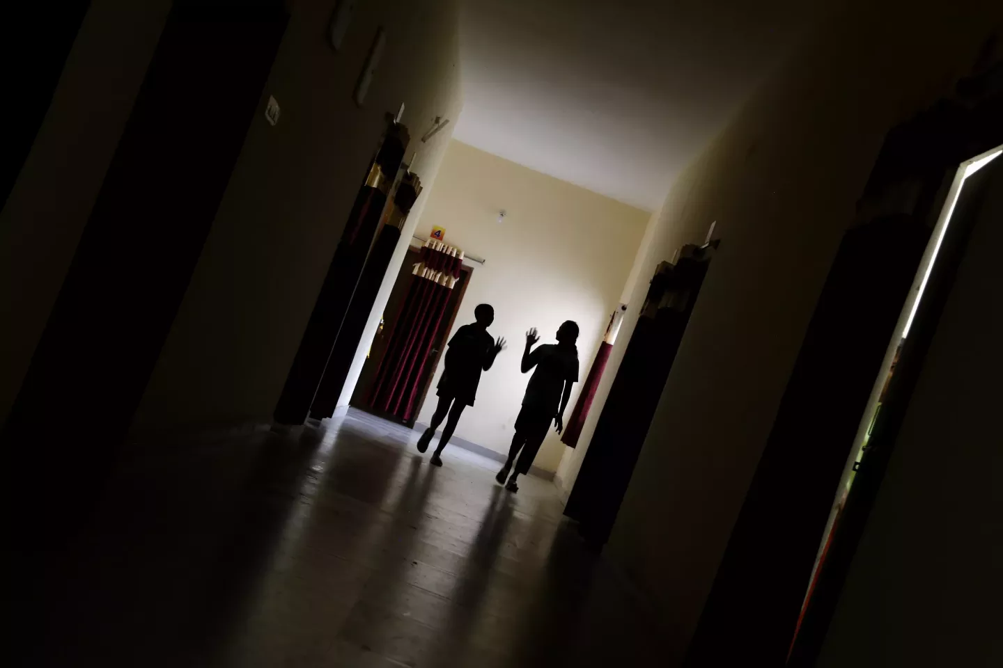 Two young girls, aged 13 and 15, walk through the corridor to attend a psychosocial group session at the Eklavya Model Residential School for Girls (EMRS) in Dantewada, Chhattisgarh, India.