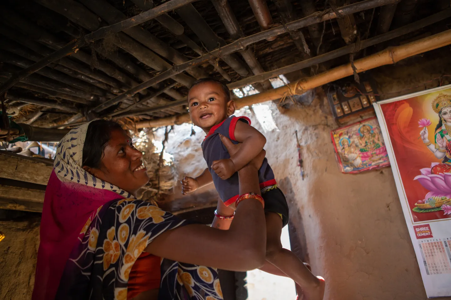 Tetri Devi holding her son Dhanraj up in the air.