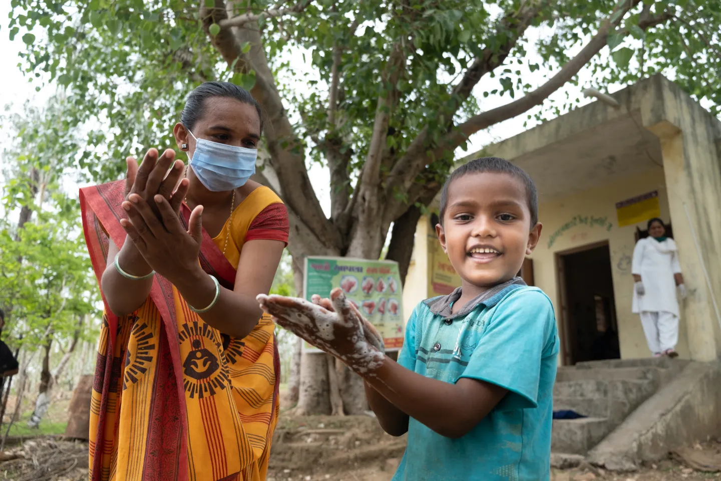 Devraj (6) receives handwasing training. AWW Madhu baira and CHO Justin Parmar conduct handwashing session for kids during Mamta Diwas session (VHND) post covid lockdown. Location : Village Kundli, Raibar, Dahod, Gujarat