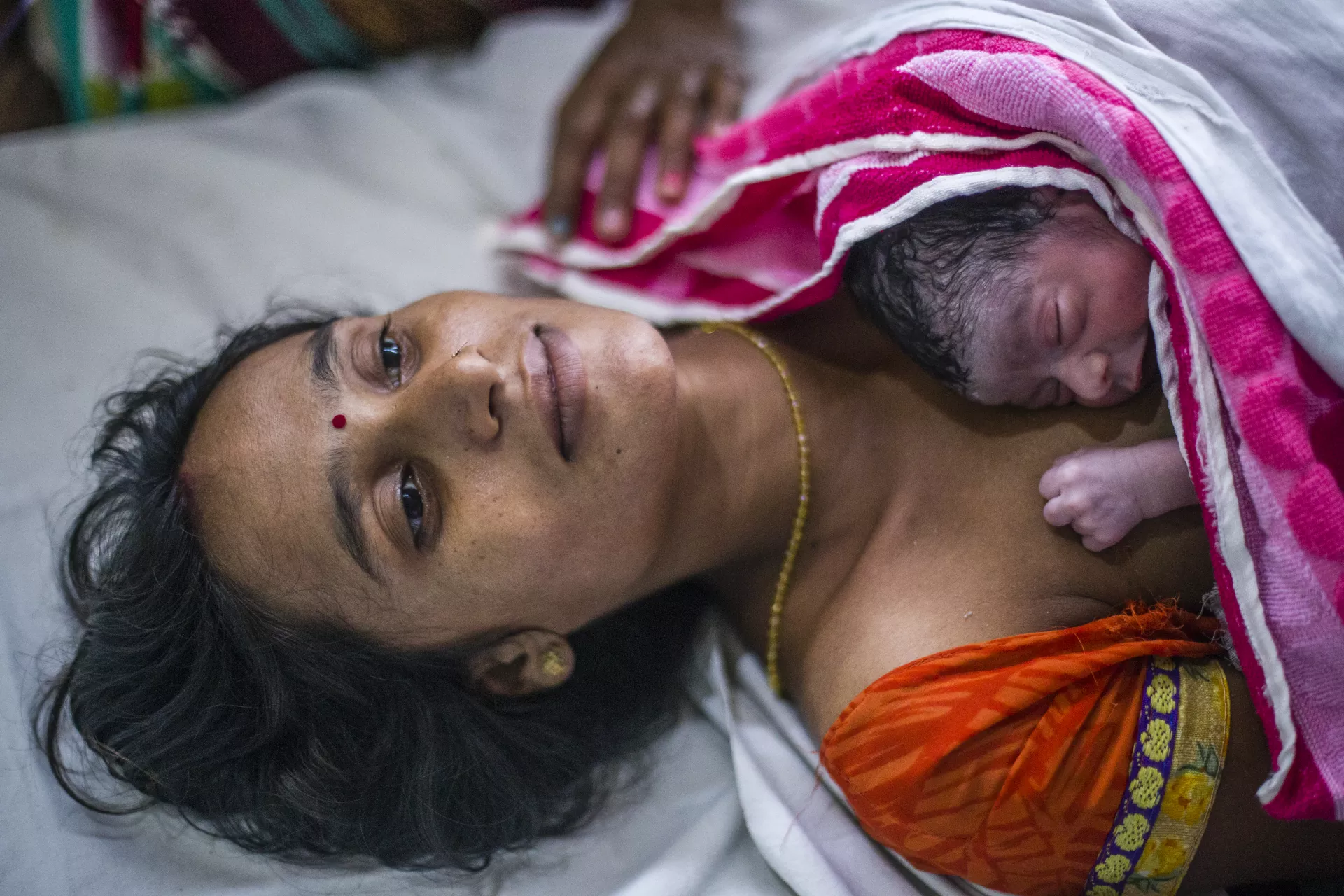 24 year old Pratima provides skin to skin contact also termed as Kangaroo Mother Care (KMC) to her new born baby at a transformed labour room in Community Health Center Kachhwan. 