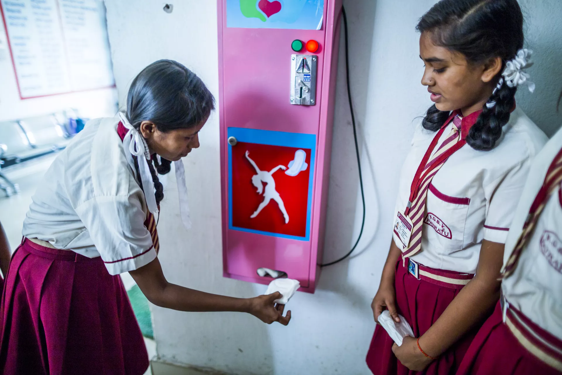 An adolescent girl takes a sanitary napkin as she uses a vending machine installed in the school during a session on Life Skill Education Module as part of Menstrual Health and Hygiene Management for Adolescents Girls project (MAHIMA) an initiative of UNICEF at Kasturba Gandhi Balika Aavasiya Vidyalaya (KGBV) in Patratu.