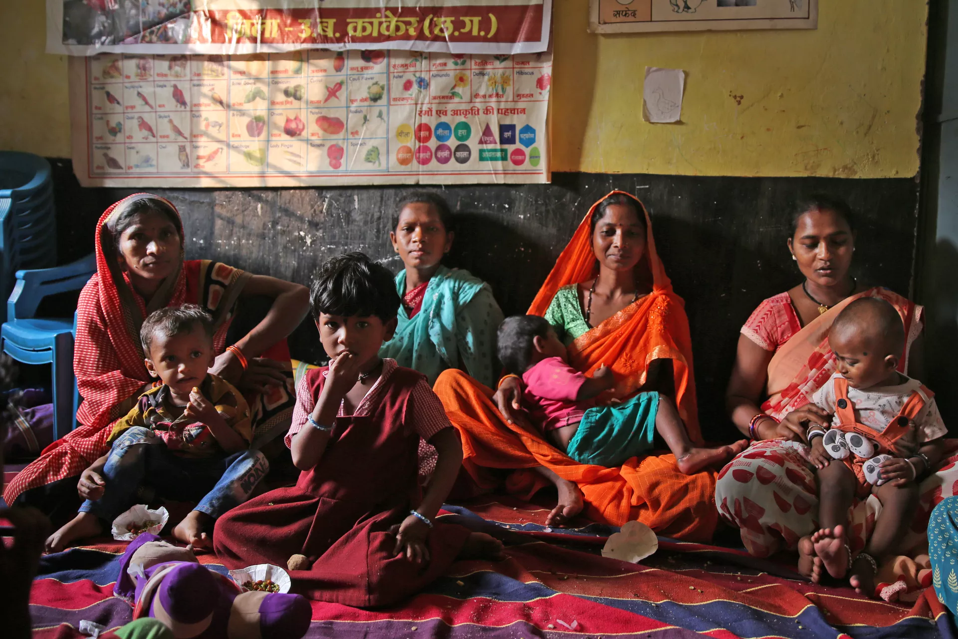 Women and kids at an Aanganwadi centre during POSHAN Abhiyaan (nutrition interventions) at Anganwadi center in Badegori, Kanker, Chhattisgarh.