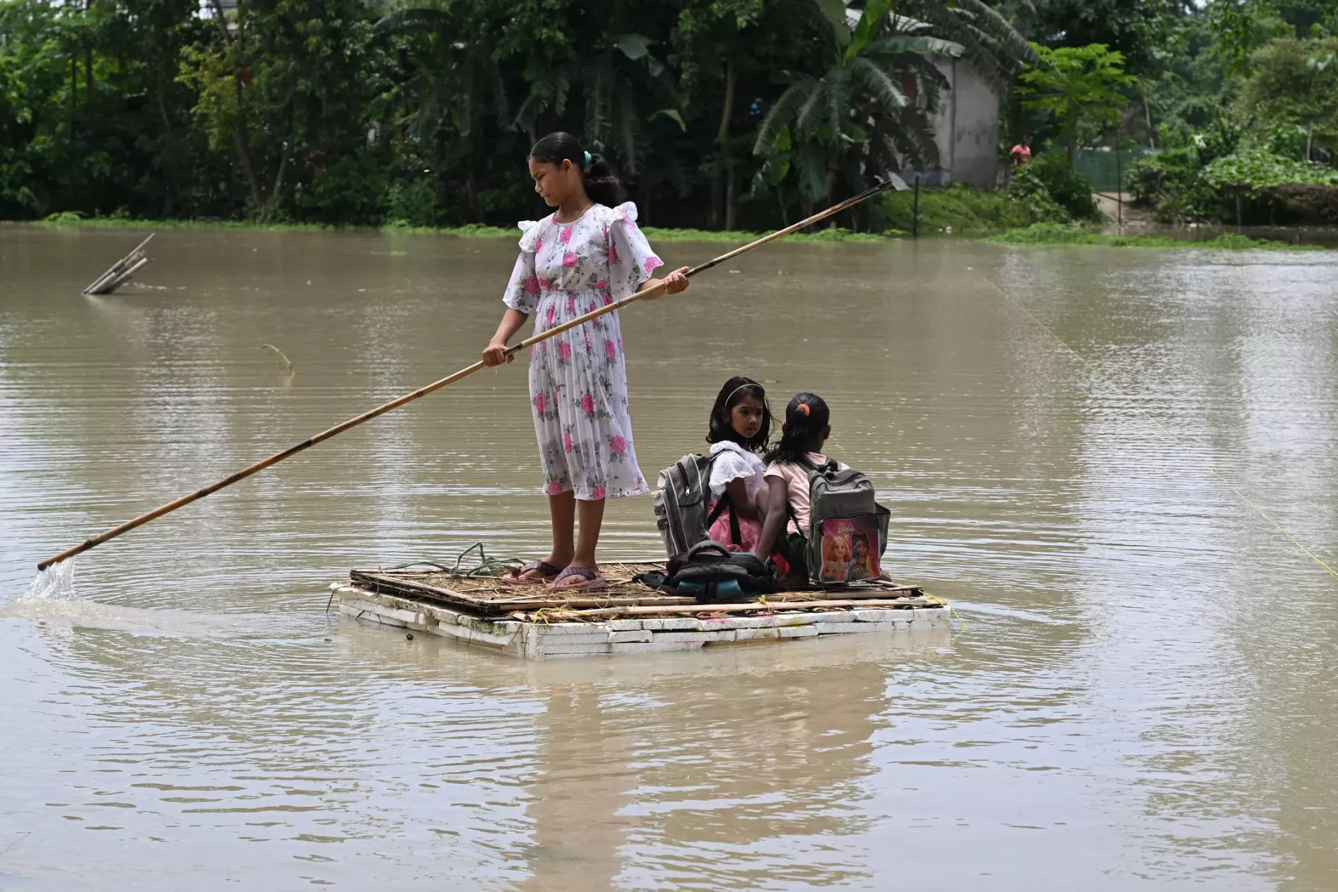 A flood affected girl paddles a raft through flood waters in Mayong village in Mayong village in Morigaon district &nbsp;July 3, 2024.