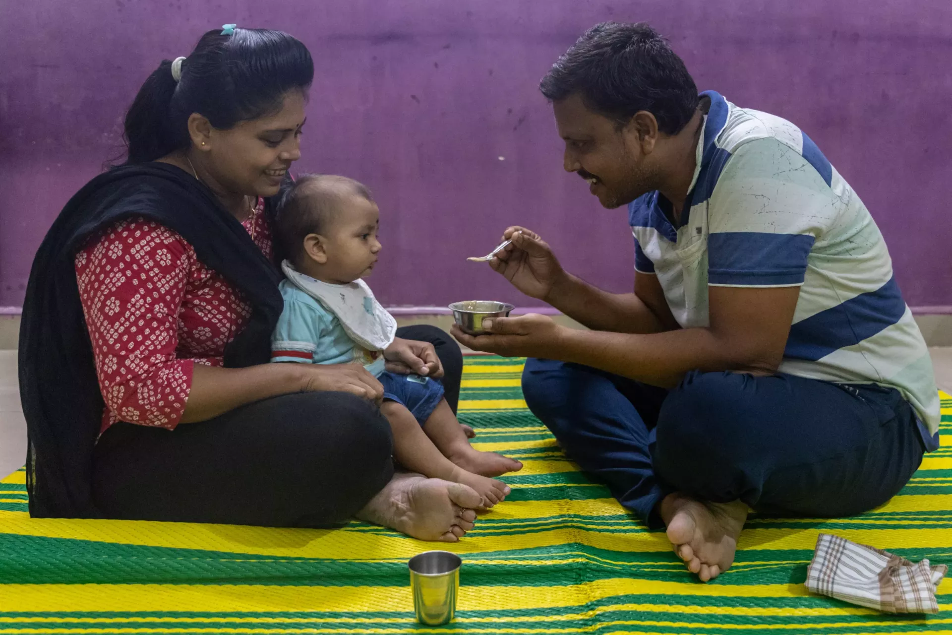 Swapnil Tamgadge, along with his wife Disha, feeds their eight months old son Shorya, at their house, in Warud village, in the District of Amravati, Maharashtra , India, 22 October 2024. 