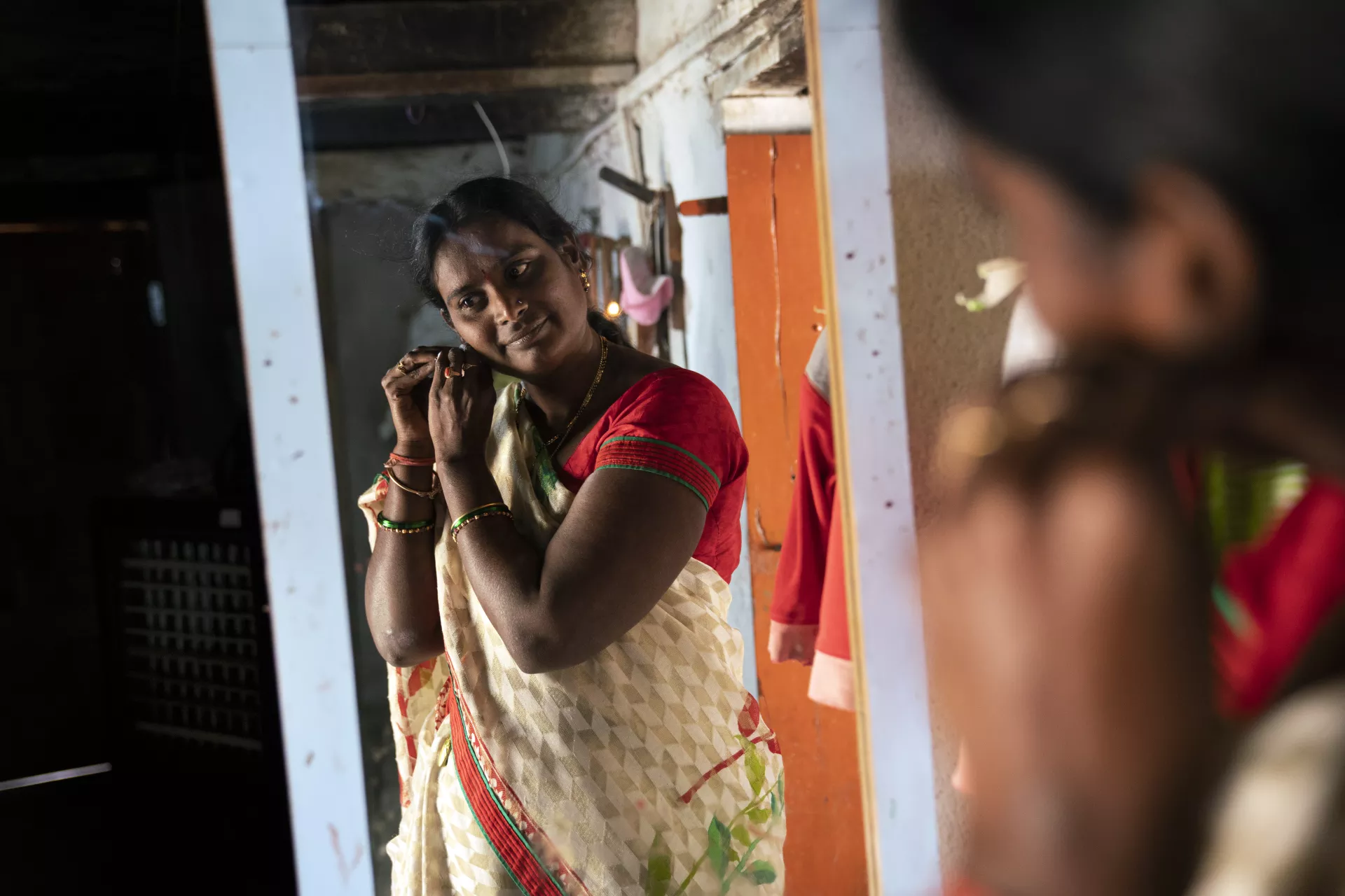 A lady looking at herself in the mirror.