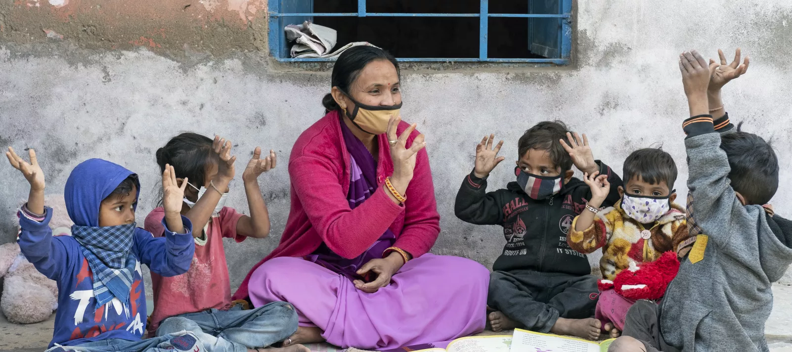 आंगनवाड़ी कार्यकर्ता लीना भट (41 वर्षीय) जेठाना के बच्चों के साथ खेल रही हैं।