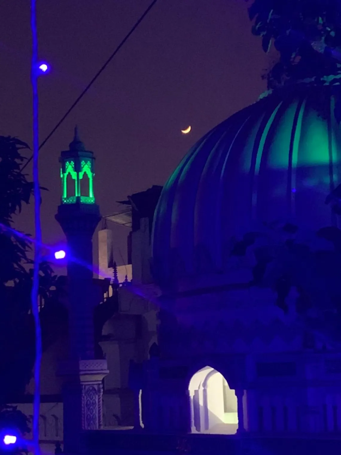 The outside of a Sufi site is lit blue with lights