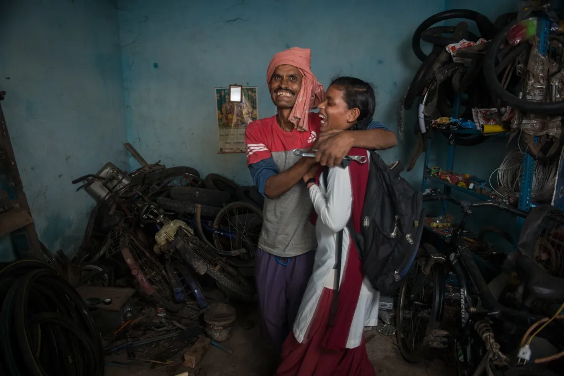Kusma Kumari hugs her father Parasnath Mahto in his shop in Kanke block of Ranchi in the central Indian state of Jharkhand.