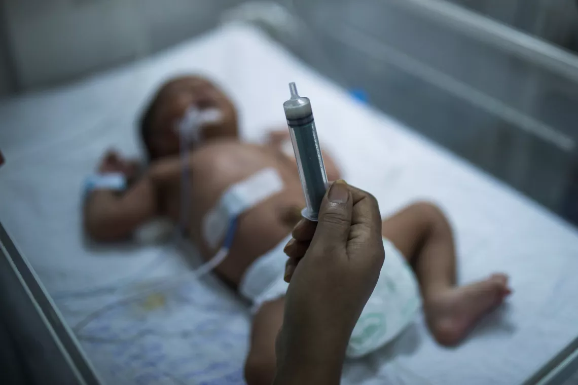 A newborn baby sleeping in a SNCU facility.
