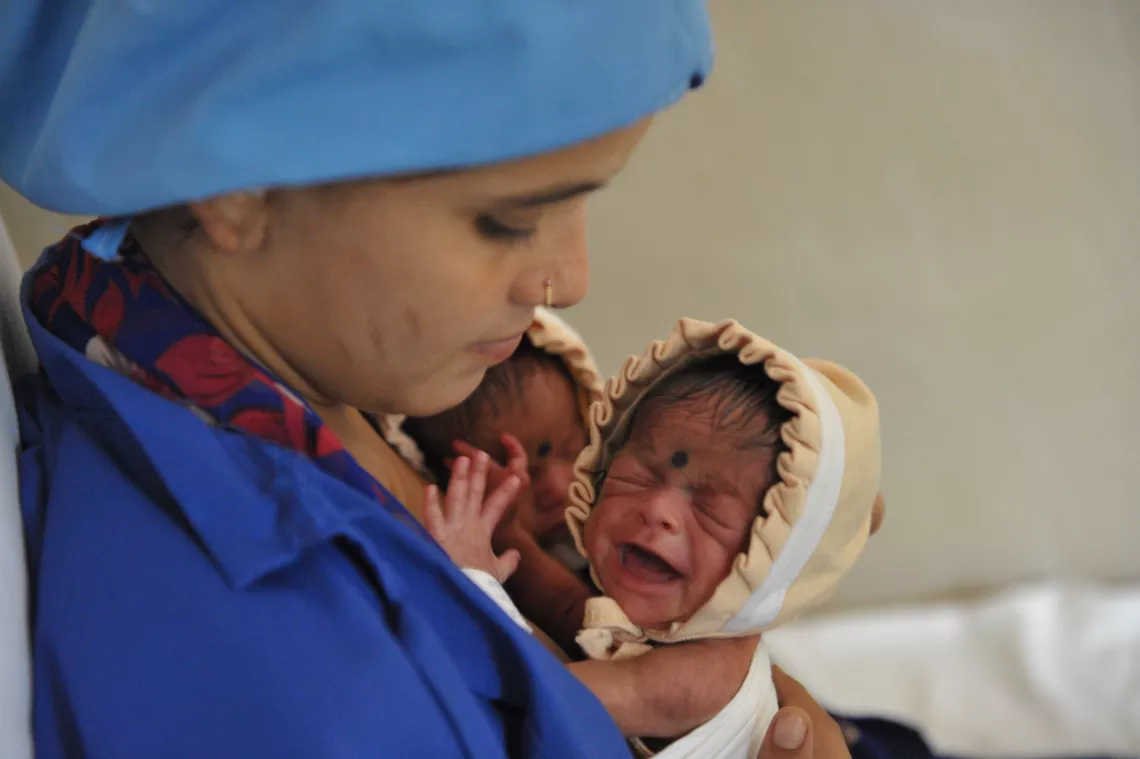 A mother with her twin boy and girl babies inside Kangaroo Mother Care (KMC) Ward at the Government hospital in Nalgonda District.