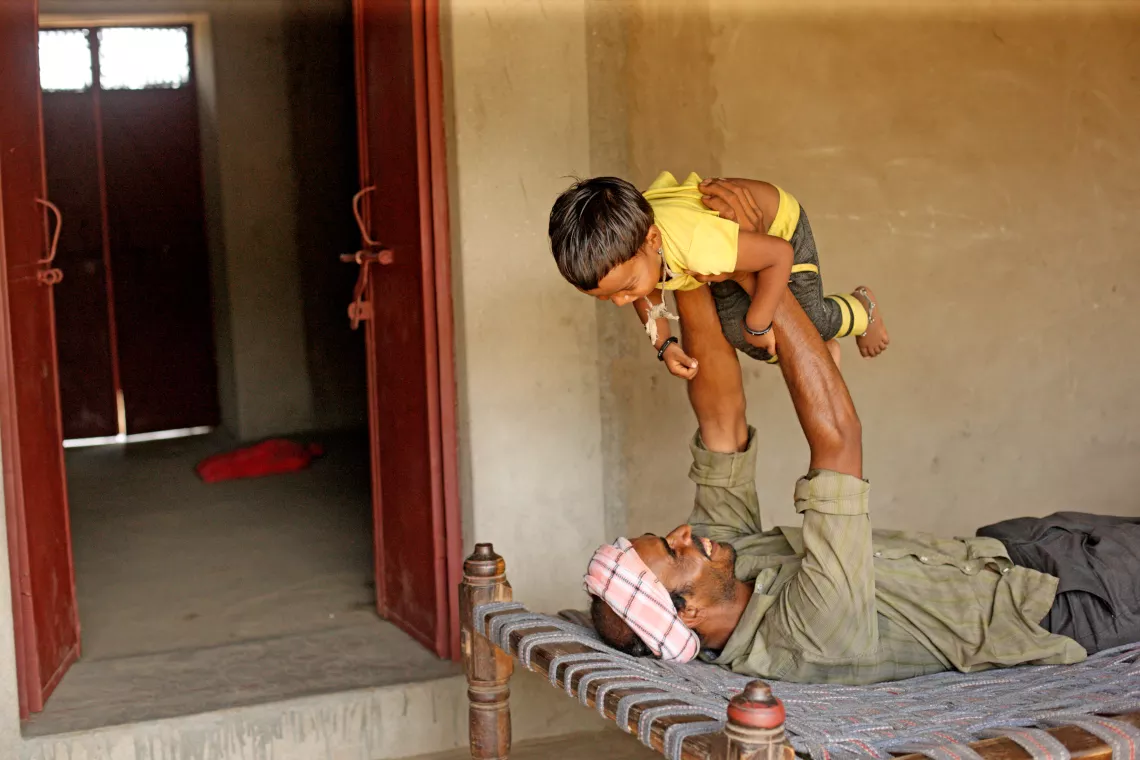 Daulat singh, 30 – year old, illiterate father playing with 3 – year – old Kanku Singh. 