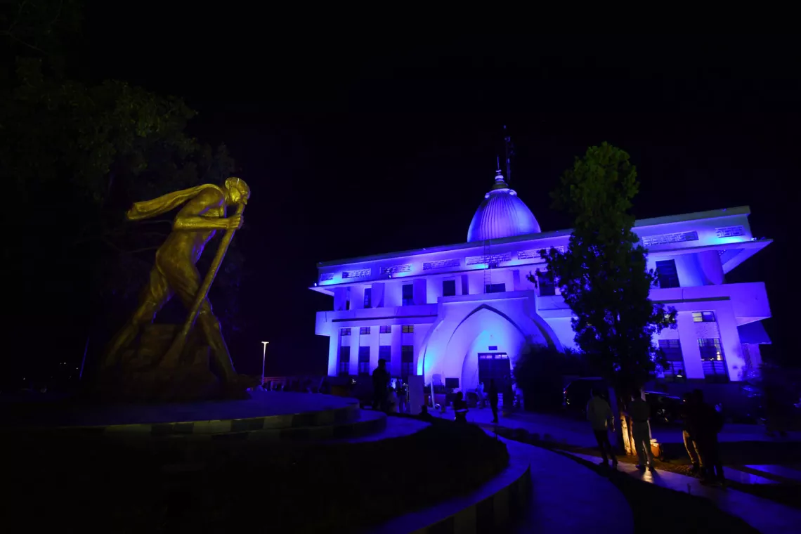 The building is lit blue with lights from outside