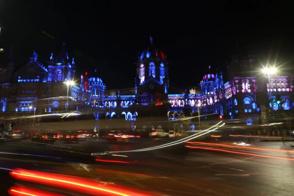 The Mumbai station is lit blue with lights at night