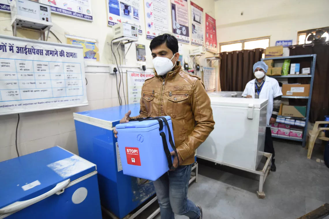 A health care worker carries 'vaccines' in a cool box as aprt of cold change from the cold chain point to the vaccination room. 