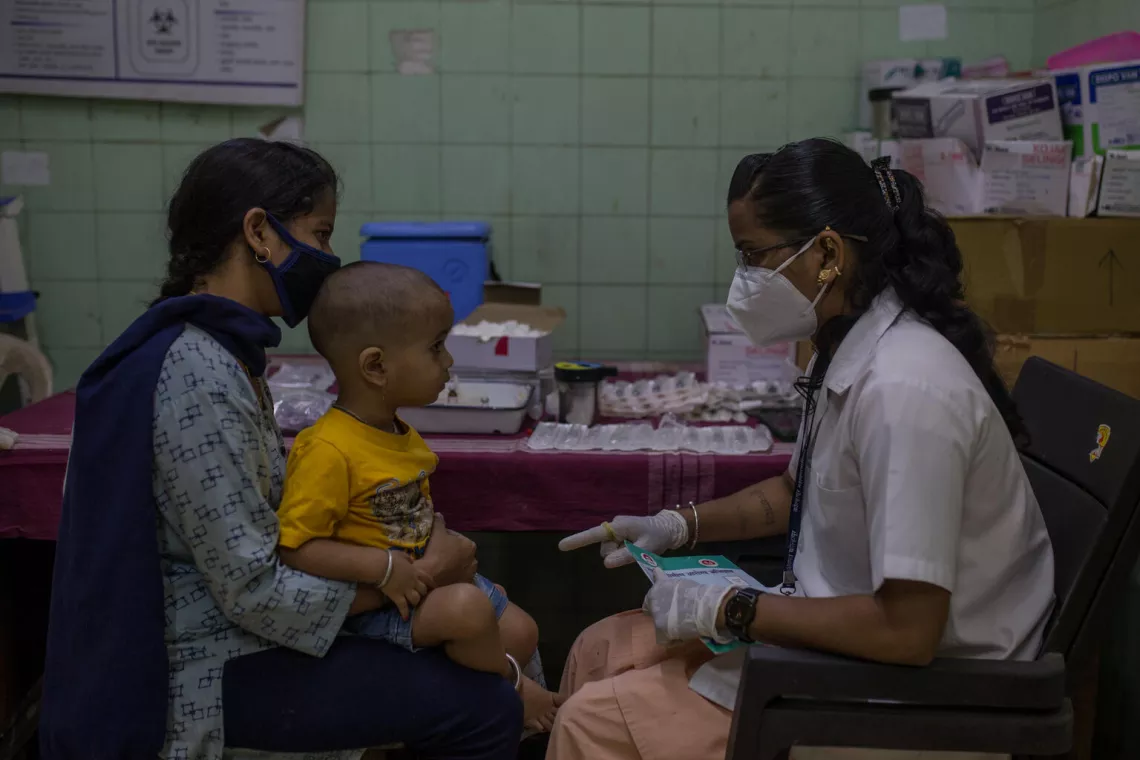 A health worker talks to a mother at a routine immunization session at a Government hospital in Maharashtra  