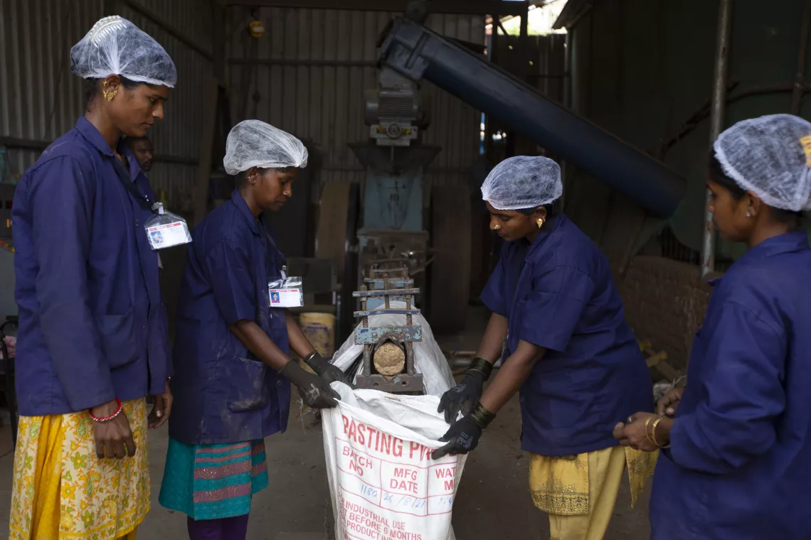 THANE, MAHARASHTRA - 18, APRIL, 2022 : A group of ragpicker women collecting briquettes from machine at Waste management centre at Samarth Bharat Vyaspeeth (SBV), a social organisation, in Thane, Maharashtra , India on April, 18, 2022. The wood waste is converted into briquettes which are renewable source of energy are produced as a replacement for fossil fuels such as oil or coal and can be used to heat boilers in manufacturing plants