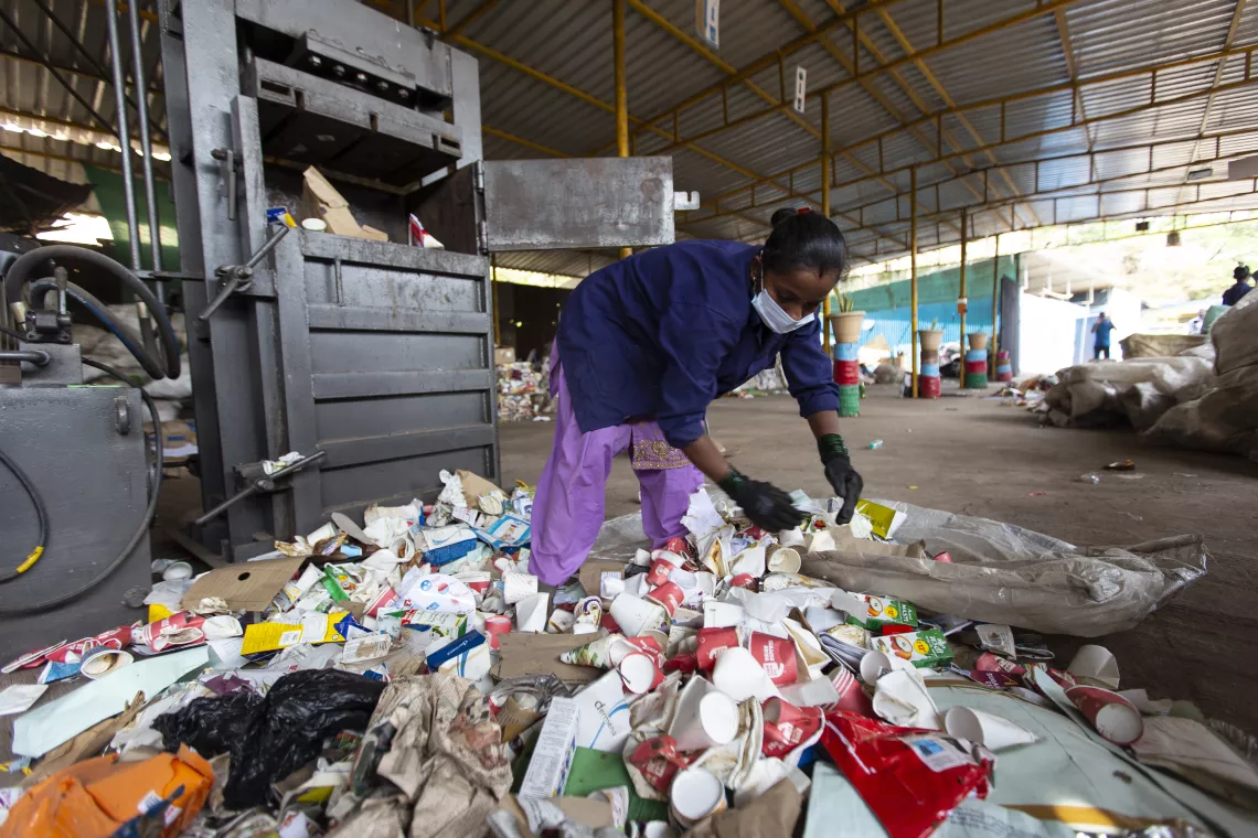 THANE, MAHARASHTRA - 18, APRIL, 2022 : A ragpicker woman pictured while sorting recyclable dry waste at the waste management centre at Samarth Bharat Vyaspeeth (SBV), a social organisation, in Thane, Maharashtra , India on April, 18, 2022. The recyclable dry waste undergoes baling process, is stored on site and provided to factories for recycling.