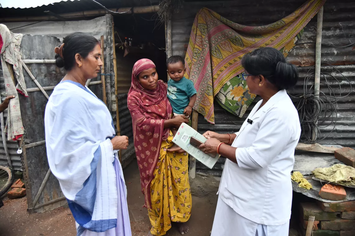 Reshmi Khatun, migrant worker with 8 month-old son Rajiful Islam and along with health workers at a brick kiln at Darrang district.