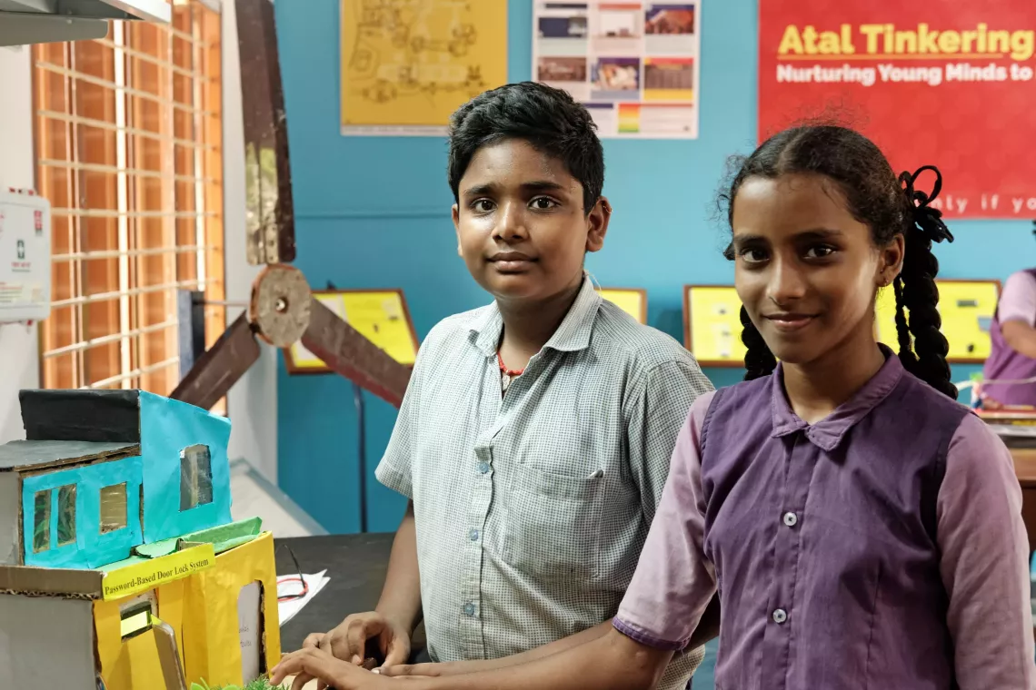 Portrait of B.Supraja (right) and A.Dileep Kumar (left), 8th and 6th grade students from Zilla Parishad High School, with a password-based door lock system where a secure password will act as a door unlocking system.