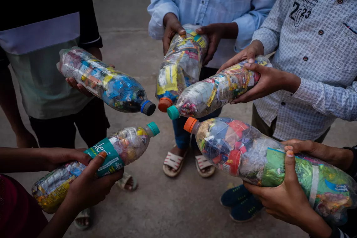 Members of the Bal Panchayat are collecting plastic waste in bottles.