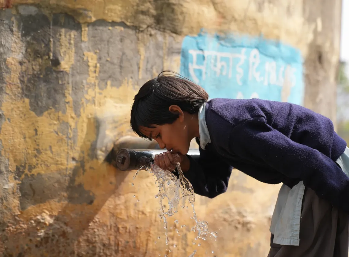 Sara drinks water outside her school in Adol village, Rajasthan. 