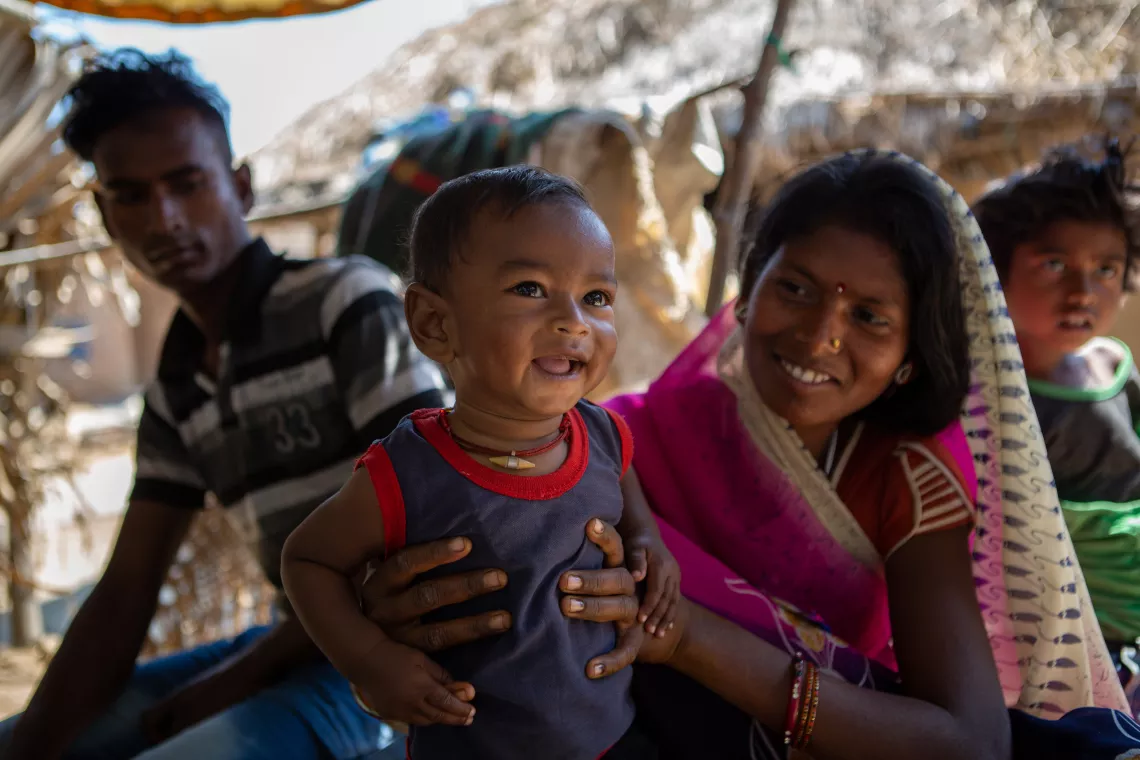 Tetri Devi holding her son Dhanraj and smiling.