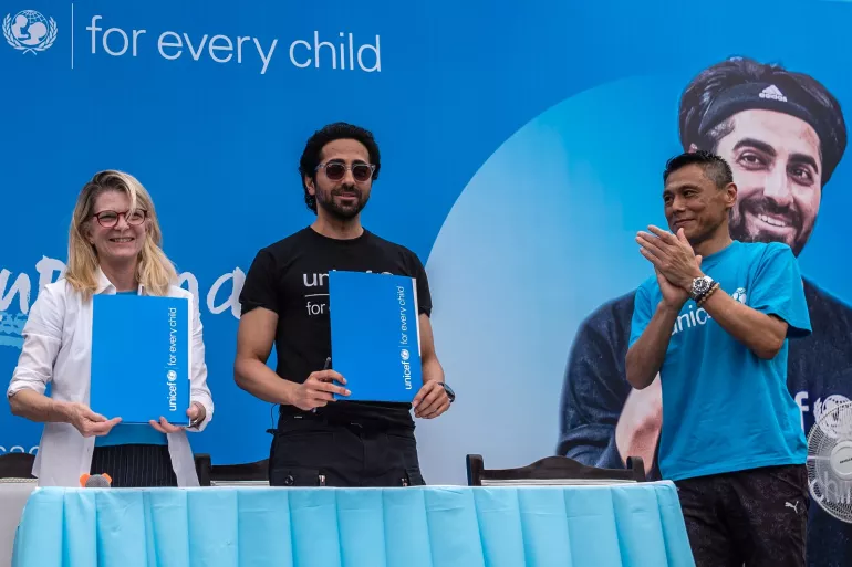 Mr. Ayushmann Khurrana (C), displays a folder containing the documents to formalise his appointment as UNICEF India National Ambassador with Ms. Cynthia McCaffrey (L) , UNICEF India Representative, and  Mr. Yasumasa Kimura (R), Deputy Representative, Programme, UNICEF India at the signing ceremony as Ayushmann Khurrana is conferred as UNICEF India national ambassador at UNICEF India  office on Saturday, 18 February 2023,Delhi,India.