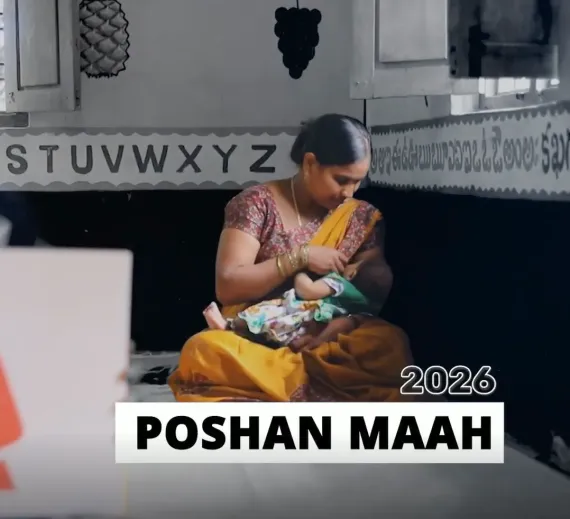 Video still of a mother breastfeeding her infant at an Anganwadi centre, with the title 'Poshan Maah 2026' displayed at the bottom of the frame.