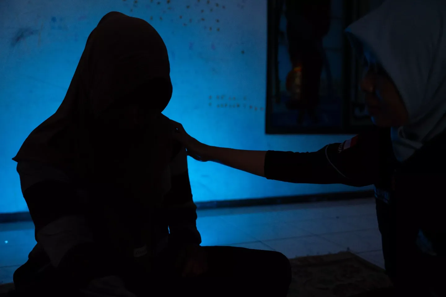 (Right to left) Ovi, a social worker, consoles Hani (name changed) the mother of Kusuma (name changed) who is a sexual victim, in their home in Klaten, Central Java, on 18 February 2025.  