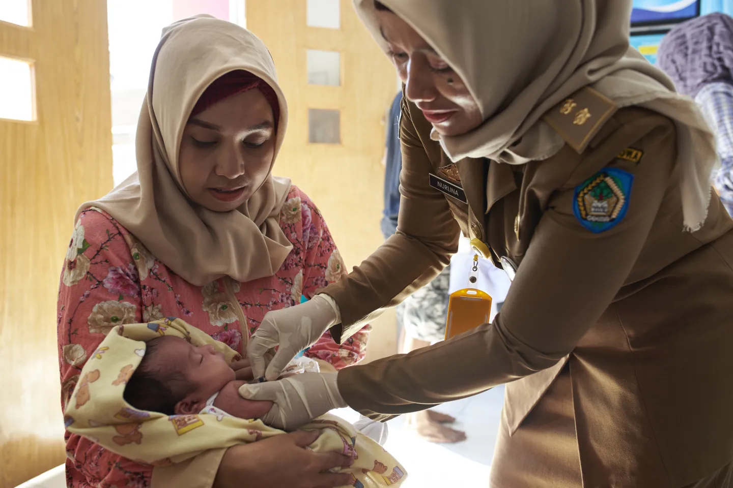 A health worker immunizes an infant against measles 
