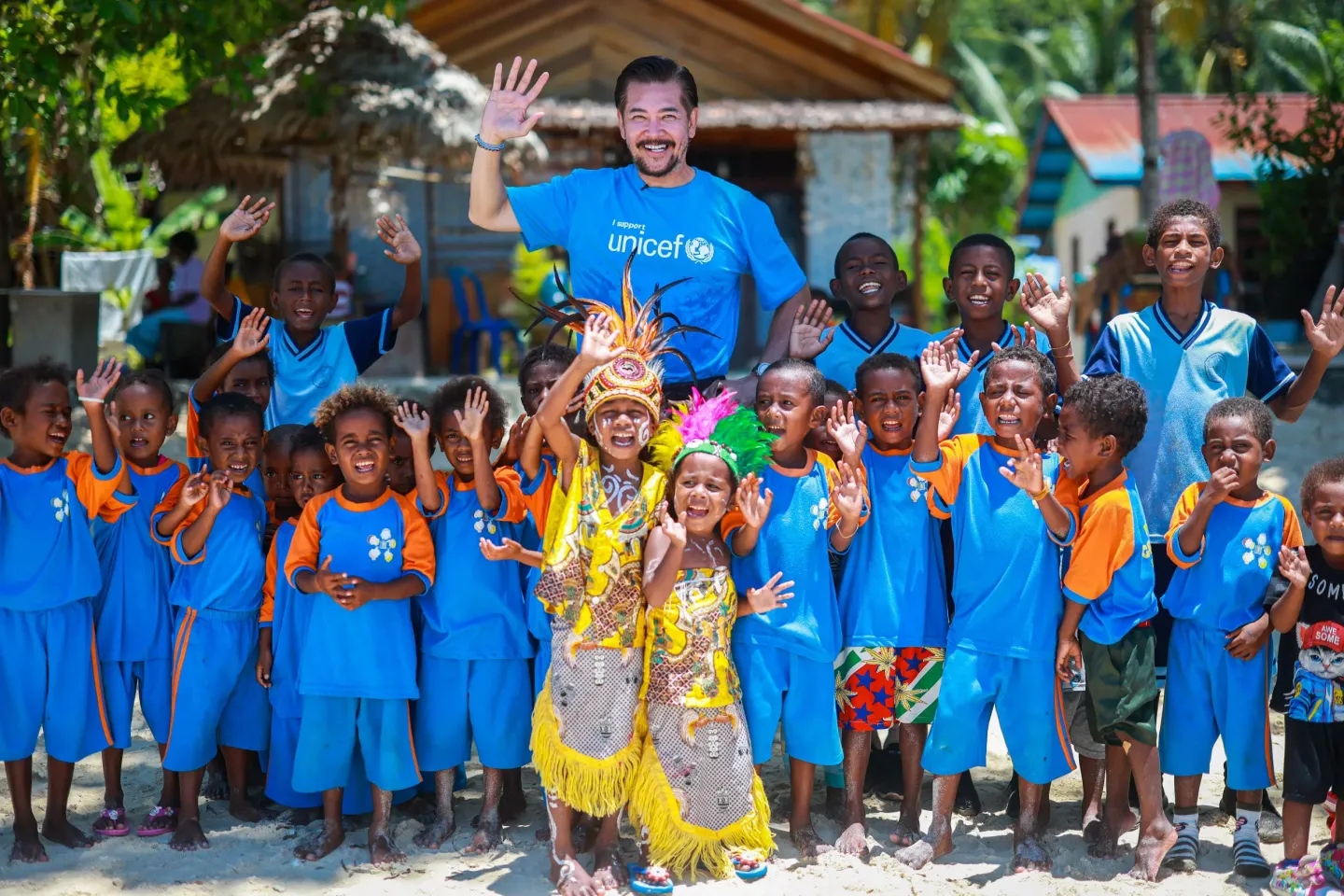 Ferry Salim and children wave their hands to the camera
