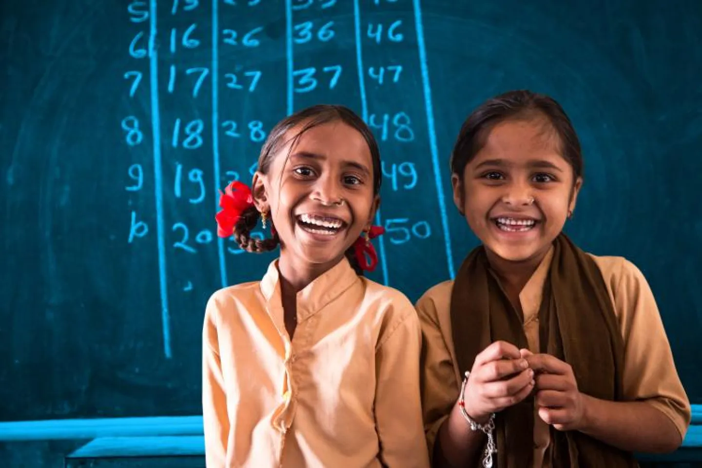 Two girls smiling in the classroom.