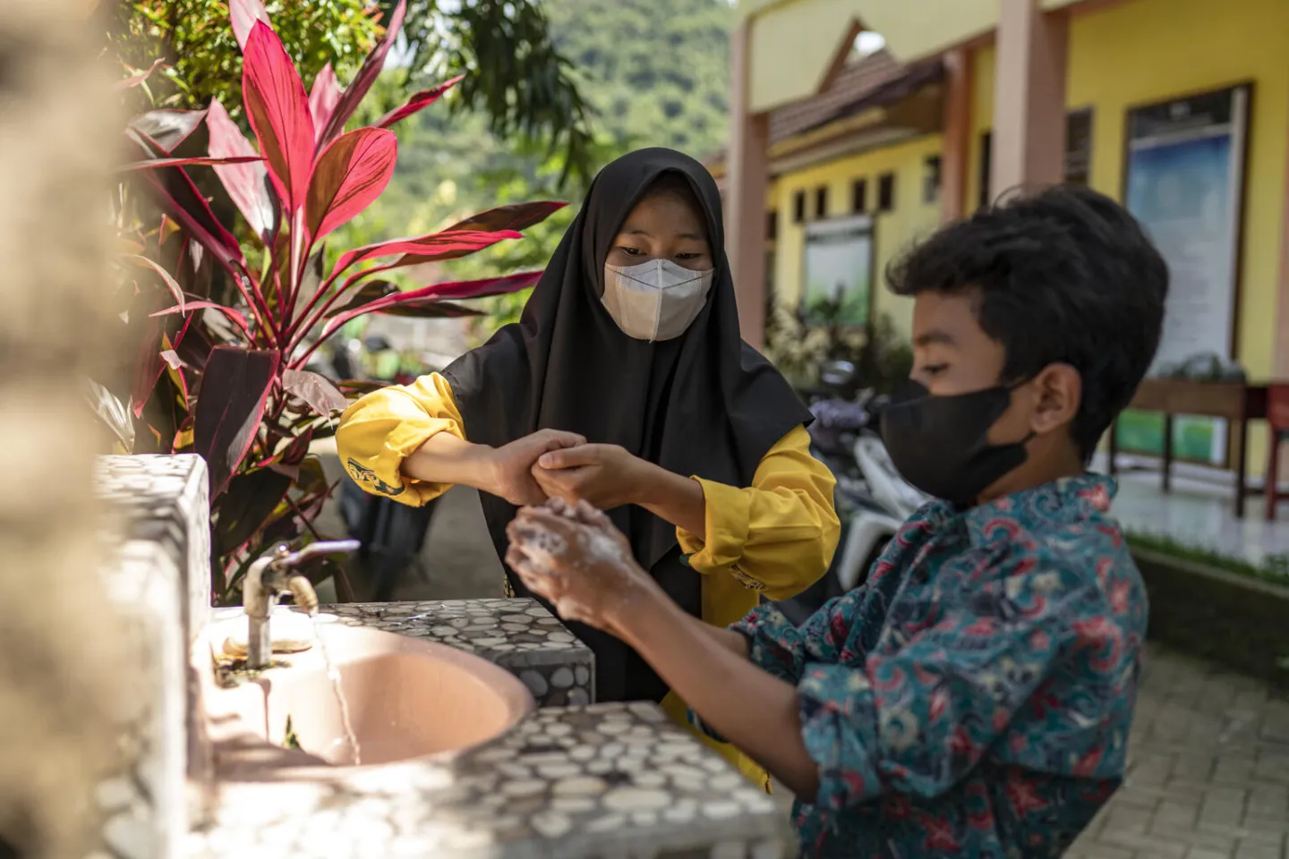 Murid-murid sedang belajar cara cuci tangan pakai sabun dengan benar.