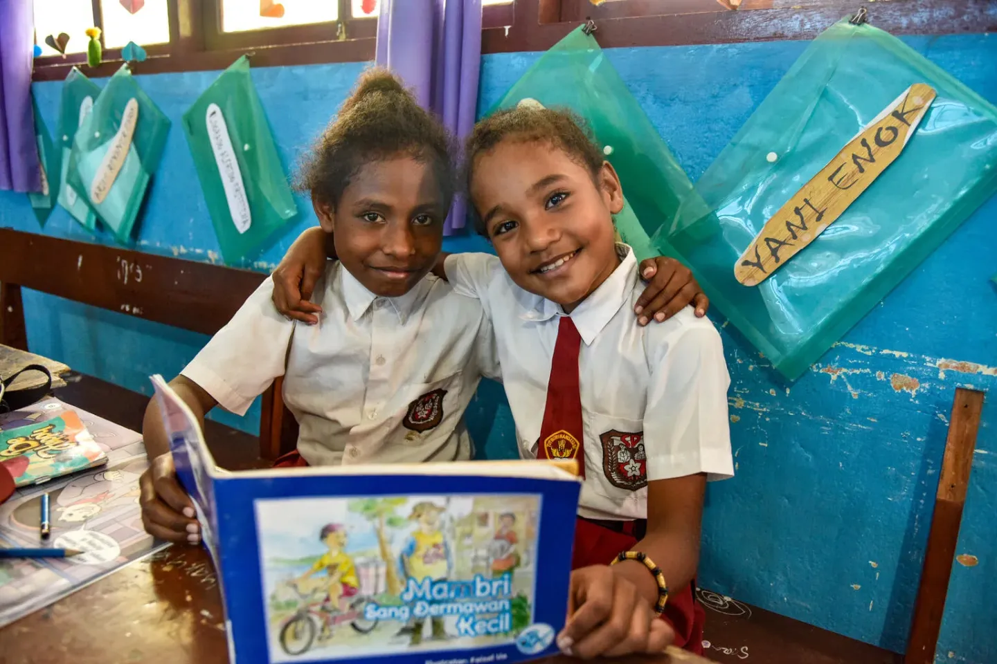 Students reading storybook available at reading corner inside their class