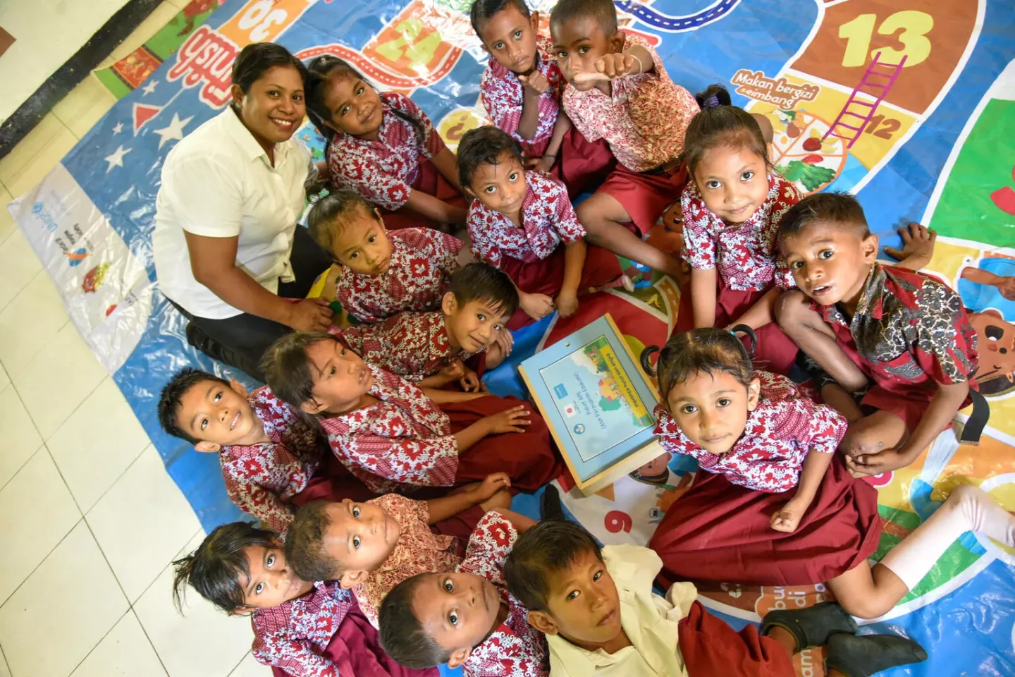 Sstudents and a teacher pose in their classroom