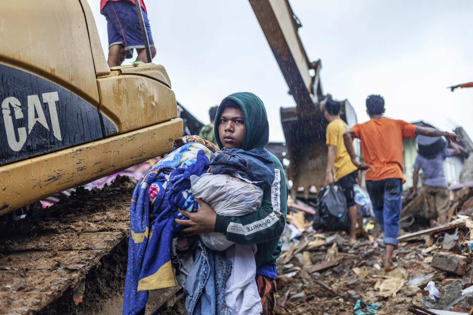 On 15 January 2021, a resident holds a pile of clothes after his house collapsed during a 6.2 magnitude earthquake in Binanga village, Mamuju, West Sulawesi, Indonesia, on 14 January 2021.