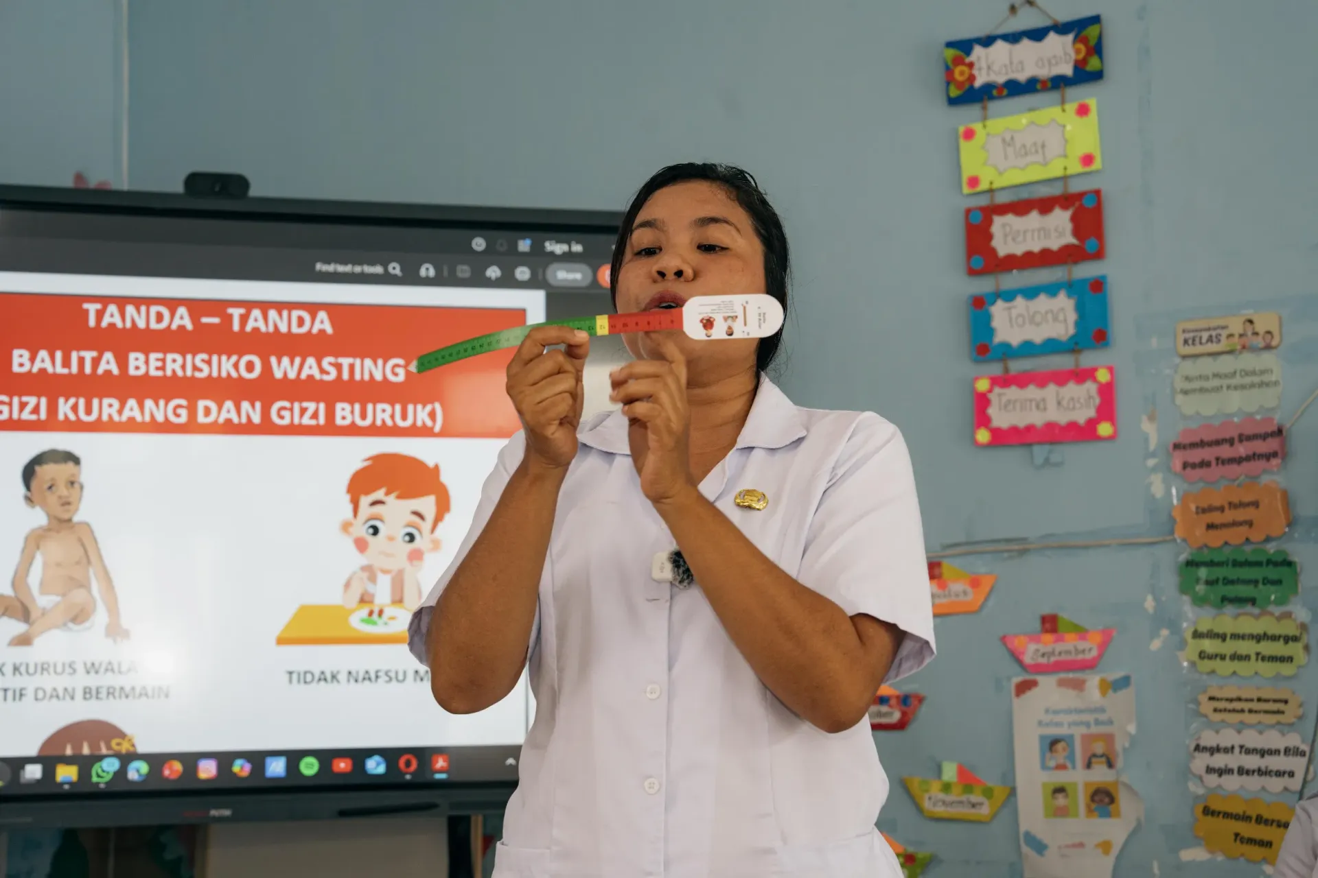 A Puskesmas staff explains about how to use the MUAC Tape