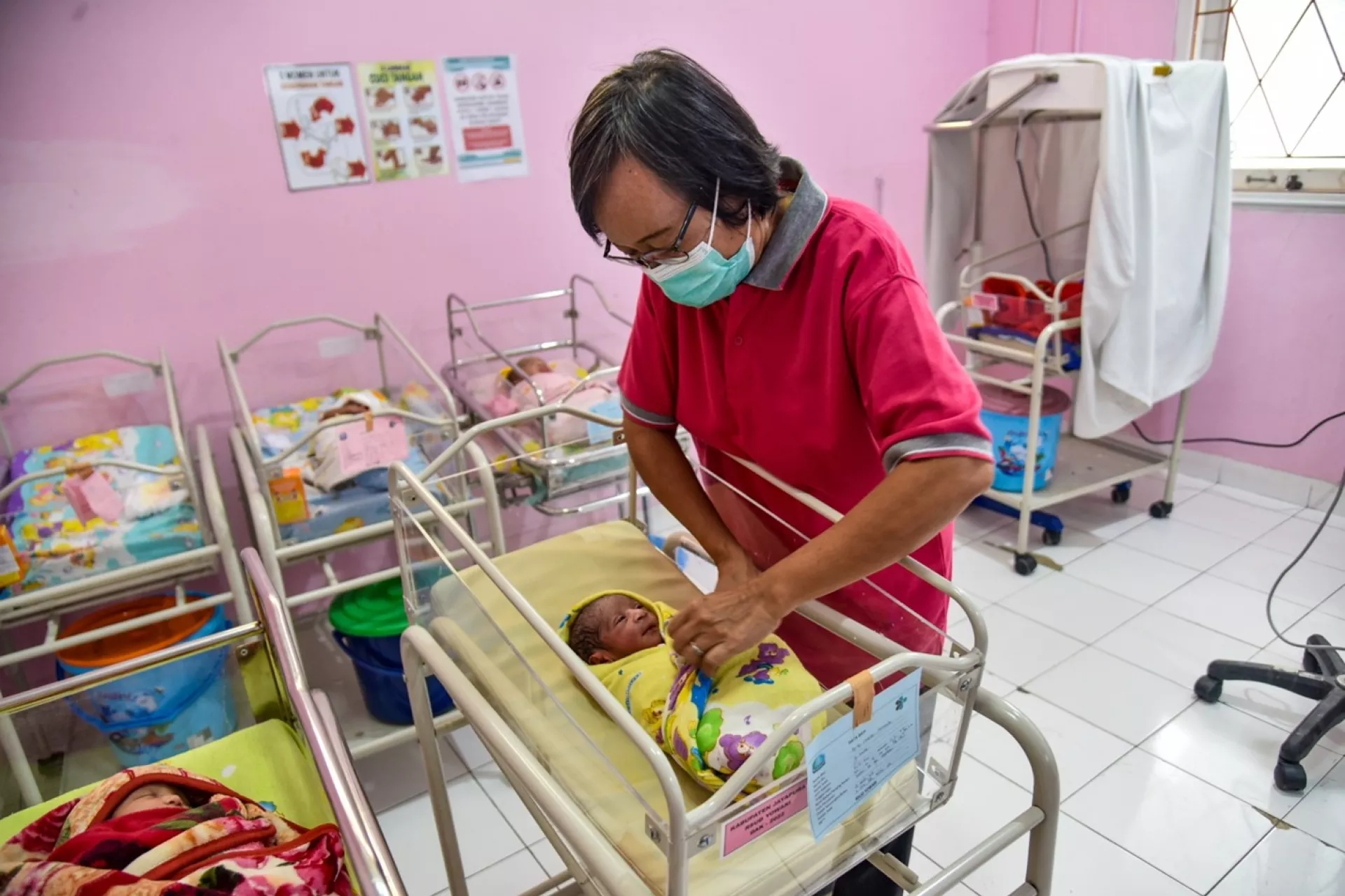 Midwife Erni Purwantini takes care of Gregorius inside the Pediatric Intensive Care Unit (PICU) at Yowari Hospital in Jayapura, Papua.