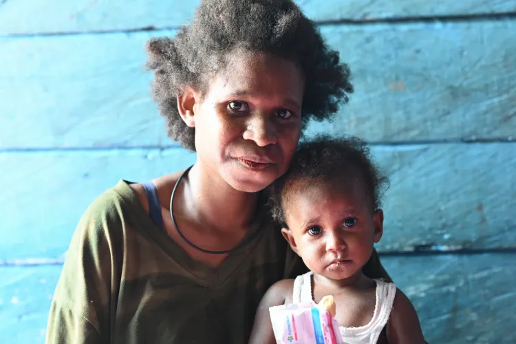 Margaretha enjoys RUTF with her mother
