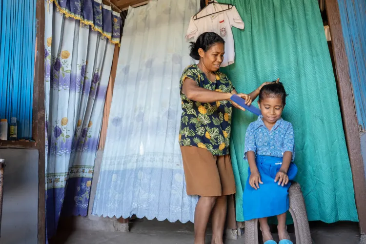 Naomi Seran helps her daughter, Lani, age six, get ready before school. Kupang District, East Nusa Tenggara Province, Indonesia.